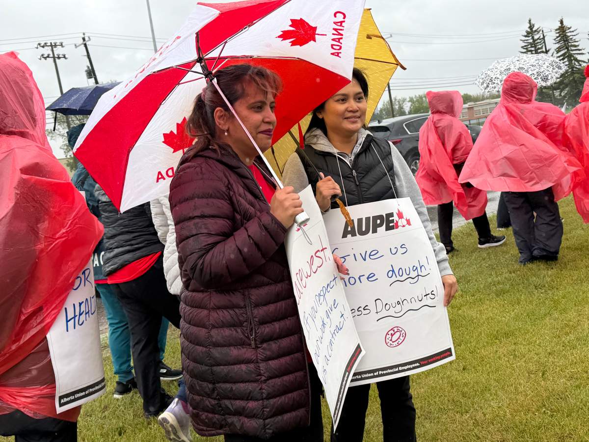 AUPE workers gather in the rain to rally for better working conditions.