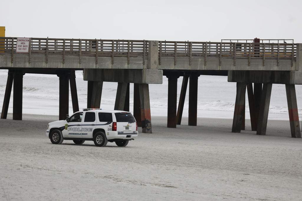 FILE: Police officers patrol the beach in Jacksonville Beach, Florida, U.S., on Saturday, April 18, 2020