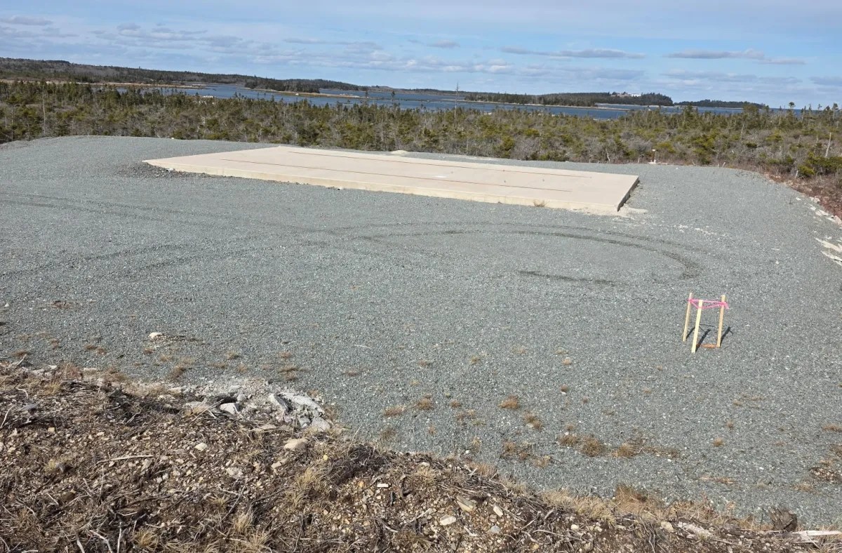 Photo shows a gravel areas with a concrete pad