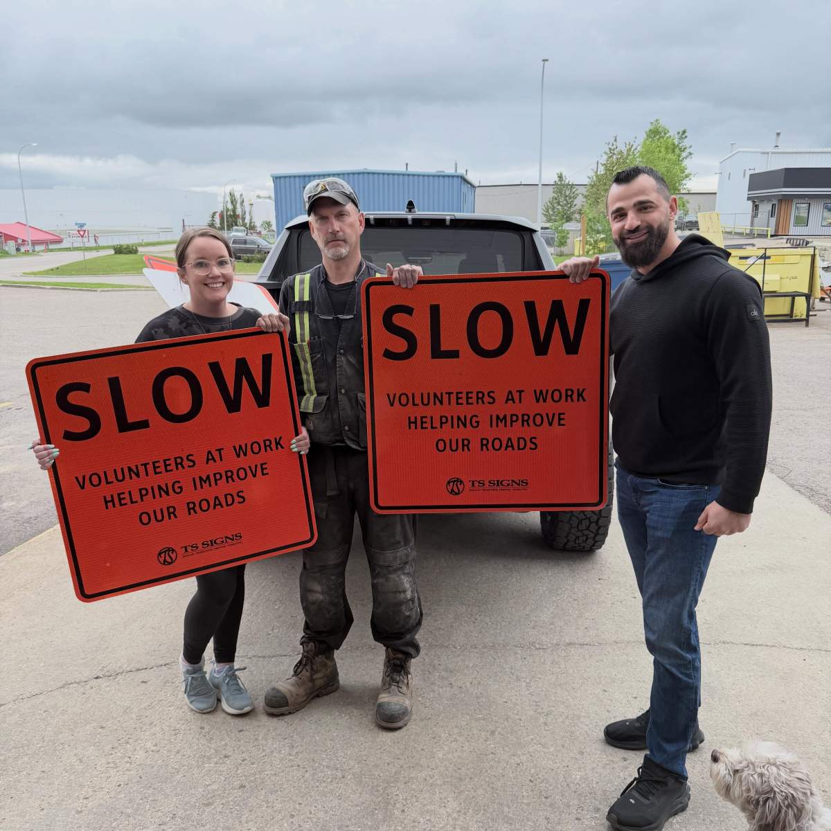 Fort McMurray residents, led by Mohamed Tarrabin (right) holding custom construction signs ahead of their citizen-led efforts to do road repairs on Highway 63 in the Alberta city. on June 12, 2026.  
