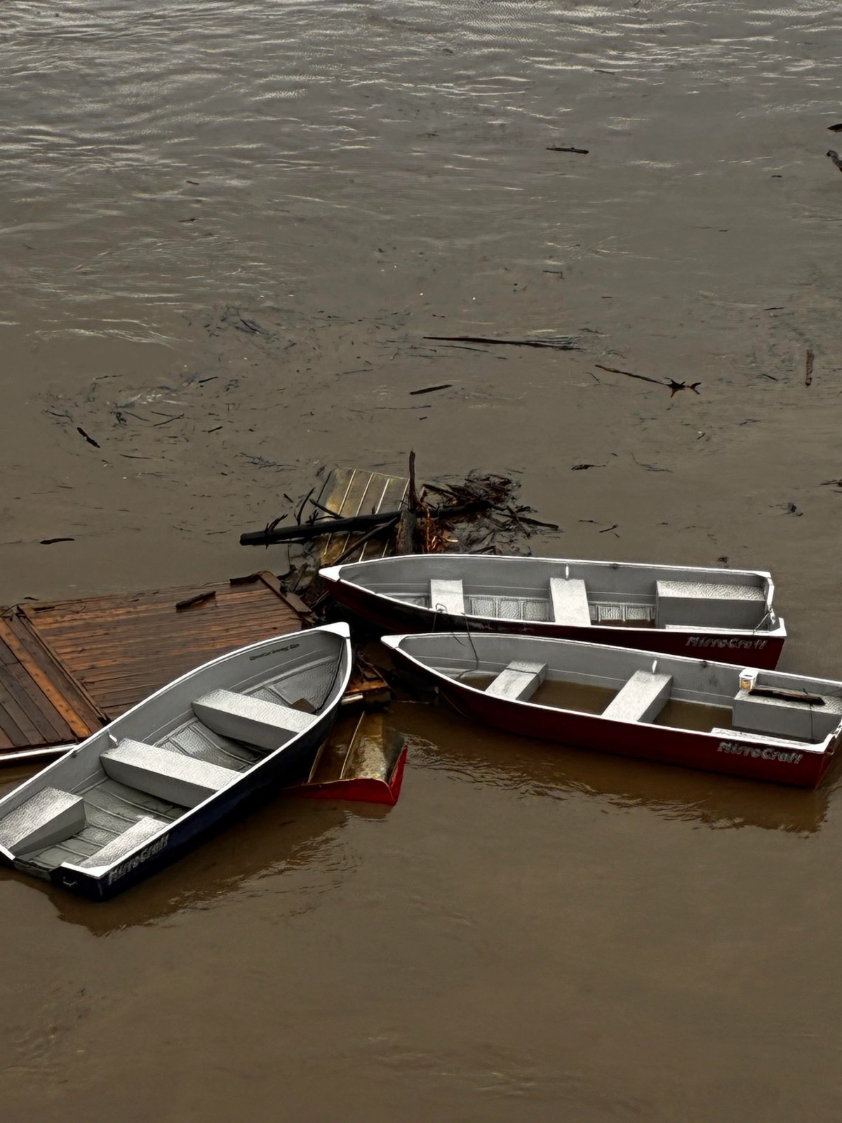 A dock with five boats attached, seen floating down the North Saskatchewan River in Edmonton, Alta. on Monday, June 22, 2026.