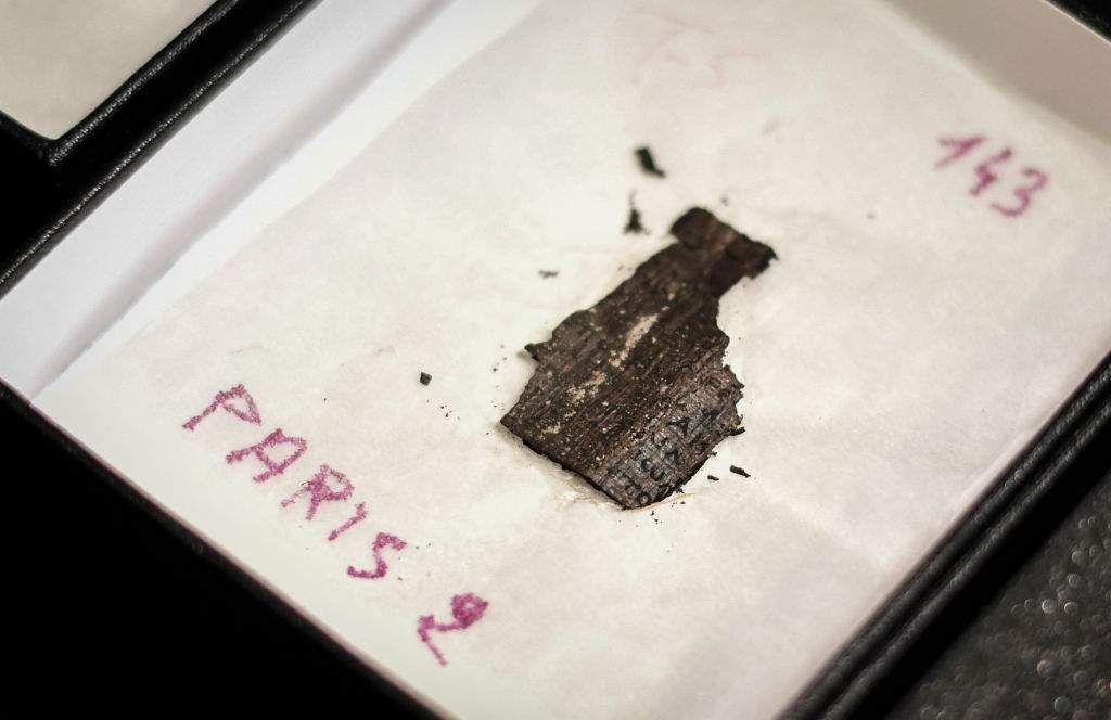 A picture taken on September 26, 2019 shows boxes with remains of Herculanum papyrus displayed at the 'Institut de France' in Paris. A leading science facility in the English countryside is helping in a bid to decipher Roman-era scrolls carbonized in the deadly eruption of Mount Vesuvius nearly 2,000 years ago.