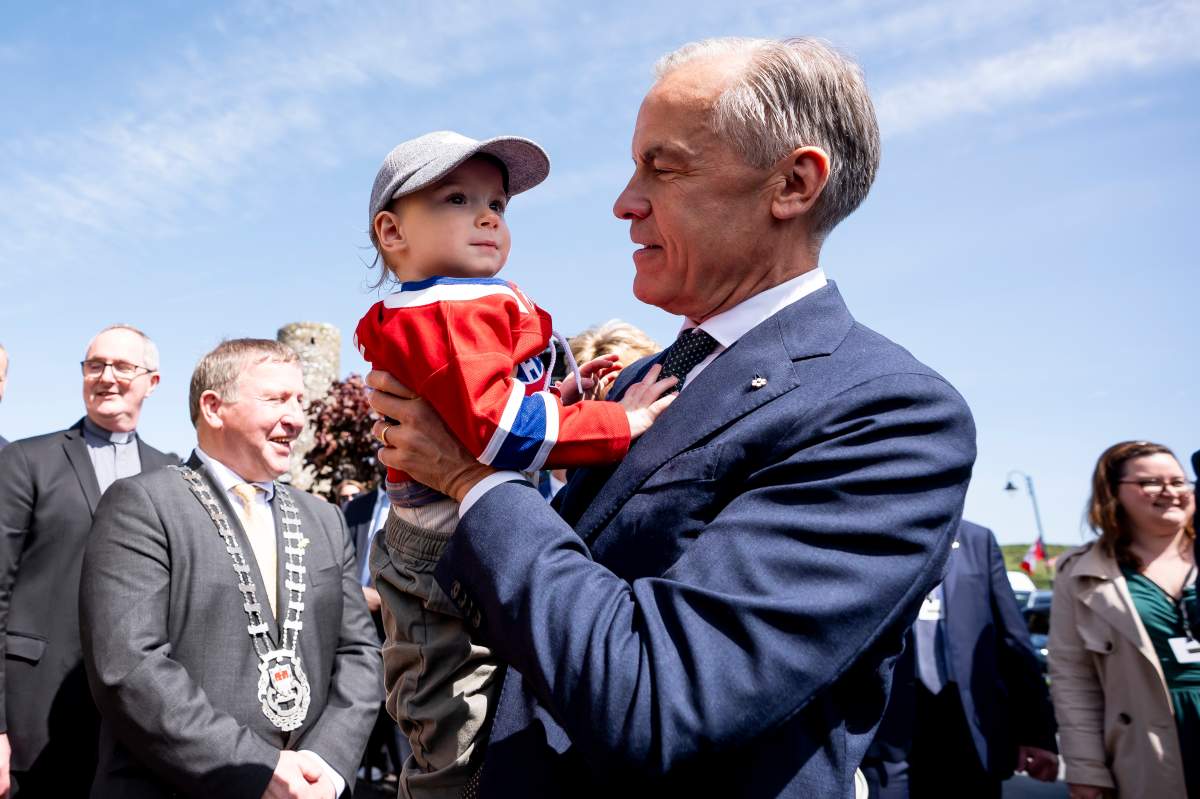 Prime Minister Mark Carney hoists 18-month-old Malachy Morgan wearing a Montreal Canadiens’ jersey, in Aghagower, County Mayo, Ireland, on Sunday, June 14, 2026.