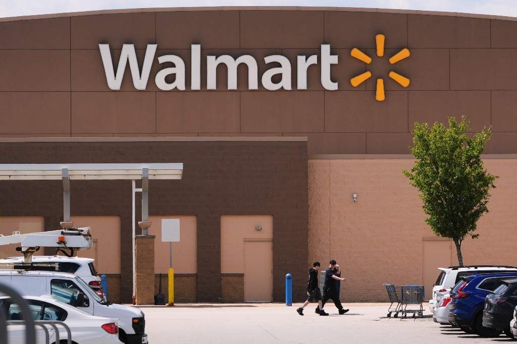 Shoppers walk from the Walmart store, Aug. 14, 2025, in Manchester, N.H.
