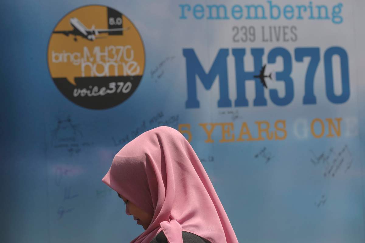 FILE - A girl stands in front of a condolence message board during a Day of Remembrance for MH370 event in Kuala Lumpur, Malaysia, on March 3, 2019. 
