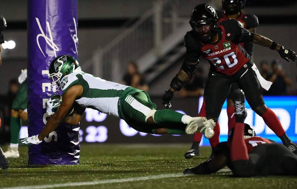 Saskatchewan RoughridersÕ KeeSean Johnson (3) scores a touchdown past Ottawa RedblacksÕ A.J. Allen (bottom right) during second half CFL football action in Ottawa on Friday, July 3, 2026. THE CANADIAN PRESS/Justin Tang.