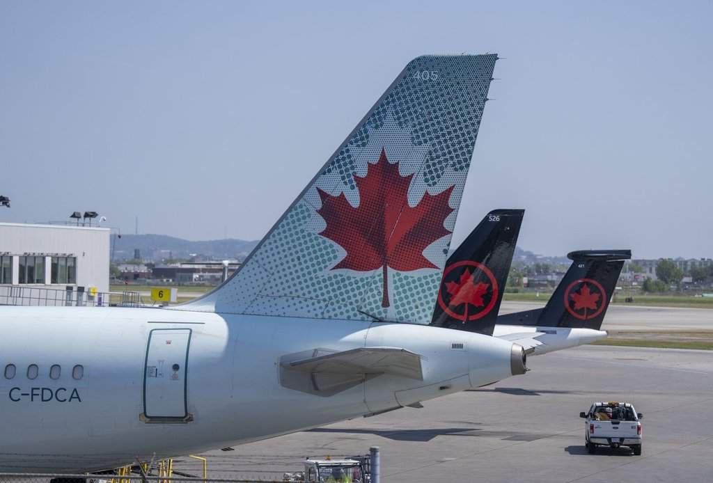 Air Canada planes sit on the tarmac at Montreal-Pierre Elliott Trudeau International Airport in Montreal, on Monday, Aug. 11, 2025. 