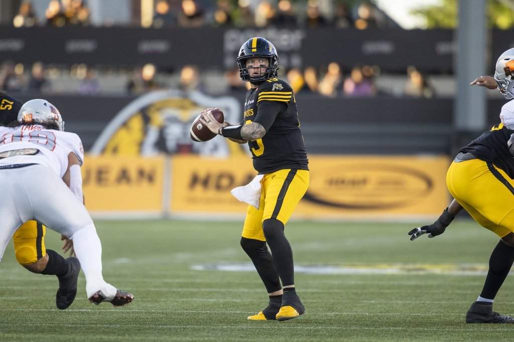 Hamilton Tiger-Cats quarterback Bo Levi Mitchell (19) looks for a pass during first half CFL football action against the B.C. Lions in Hamilton on Friday, June 19, 2026. THE CANADIAN PRESS/Nick Iwanyshyn.