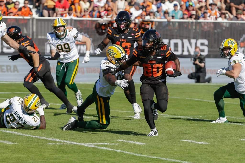 B.C. Lions' James Butler (20) runs past Edmonton Elks' Richard Jibunor (96) during first half CFL football action in Kelowna, B.C., on Saturday July 4, 2026. THE CANADIAN PRESS/Steve Dunsmoor.