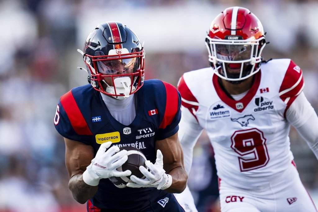 Montreal Alouettes' Tyson Philpot (6) makes a catch against Calgary Stampeders' Damon Webb (9) during first half CFL football action in Montreal on Saturday, July 11, 2026. THE CANADIAN PRESS/Christopher Katsarov.
