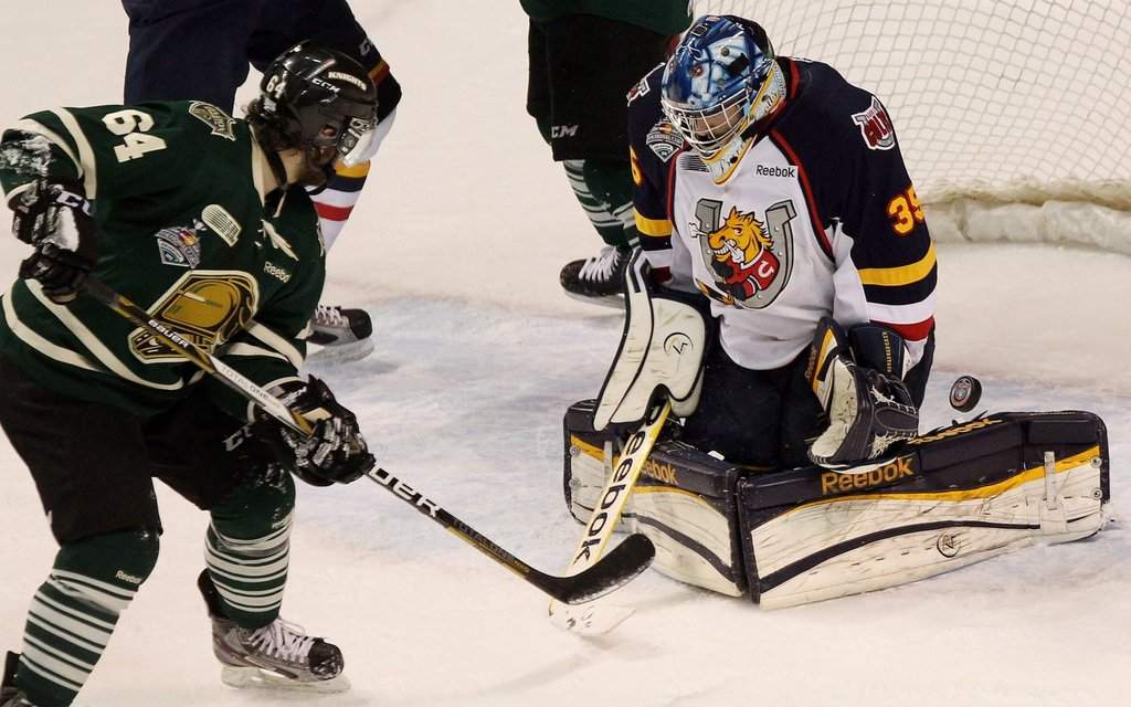 Knights forward Ryan Rupert watches Barrie Colts goaltender Mathias Niederberger deflects a shot wide in London, Ont., on May 13, 2013. THE CANADIAN PRESS/Dave Chidley.