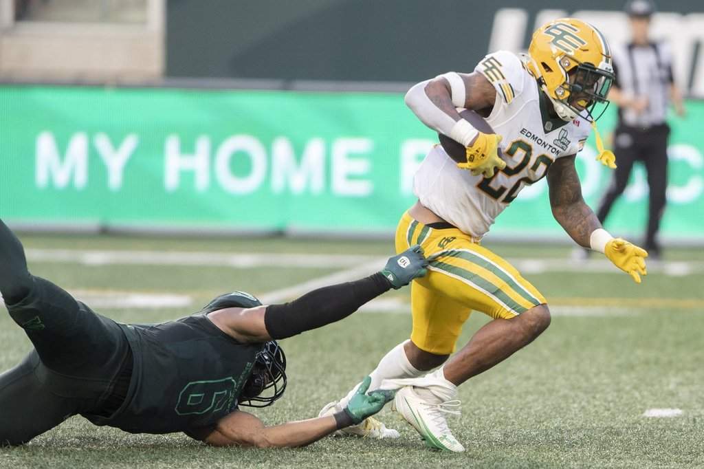 Edmonton Elks running back Javon Leake (22) runs the ball as Saskatchewan Roughriders linebacker Jameer Thurman (6) tries to make a tackle during first half CFL football action in Regina on Thursday, July 23, 2026. THE CANADIAN PRESS/Kayle Neis.