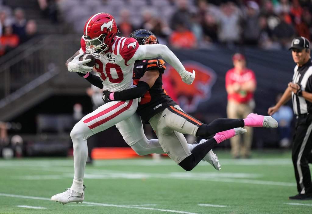 Calgary Stampeders' Damien Alford, front left, is tackled by B.C. Lions' Robert Carter Jr. after making a reception during the first half of a CFL football game, in Vancouver, Saturday, Oct. 4, 2025. THE CANADIAN PRESS/Darryl Dyck.