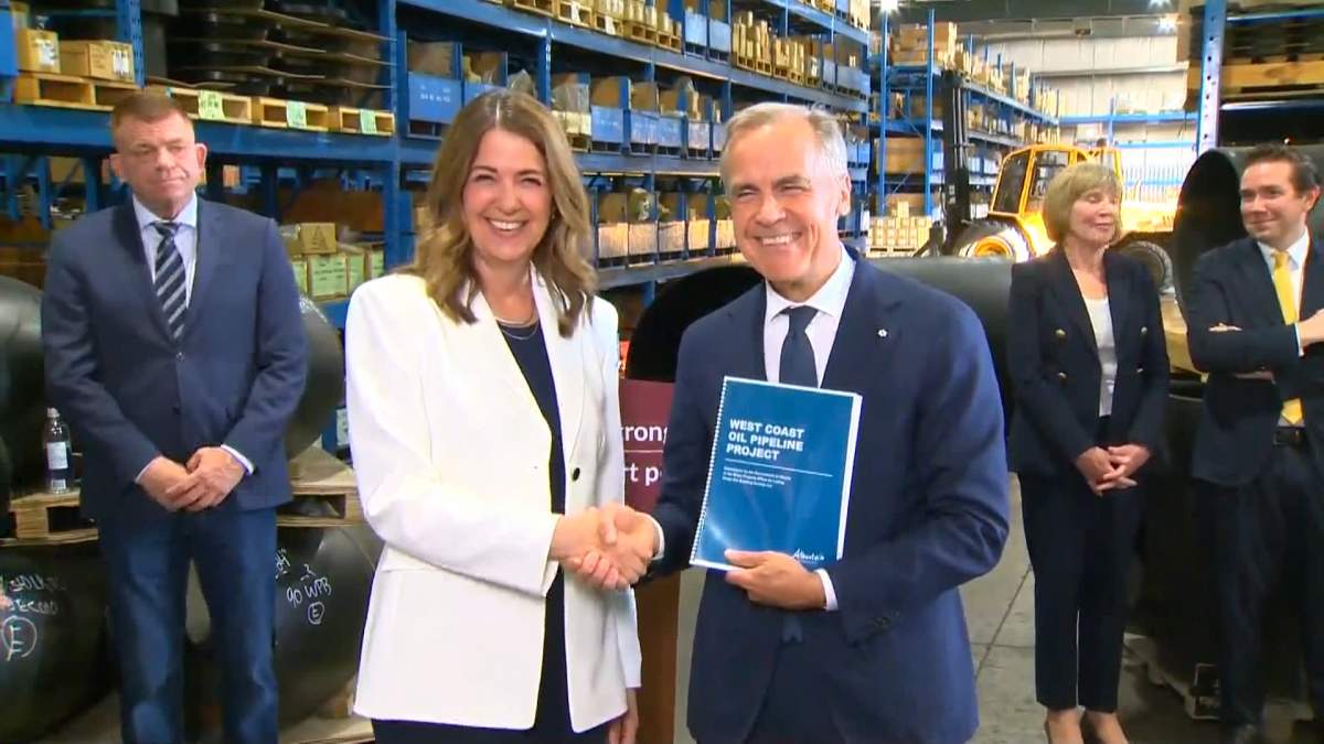 Prime Minister Mark Carney and Alberta Premier Danielle Smith pose with a copy of the proposal for a new oil pipeline from Alberta to B.C. after it was presented Thursday to the federal government's "Major Projects" office.