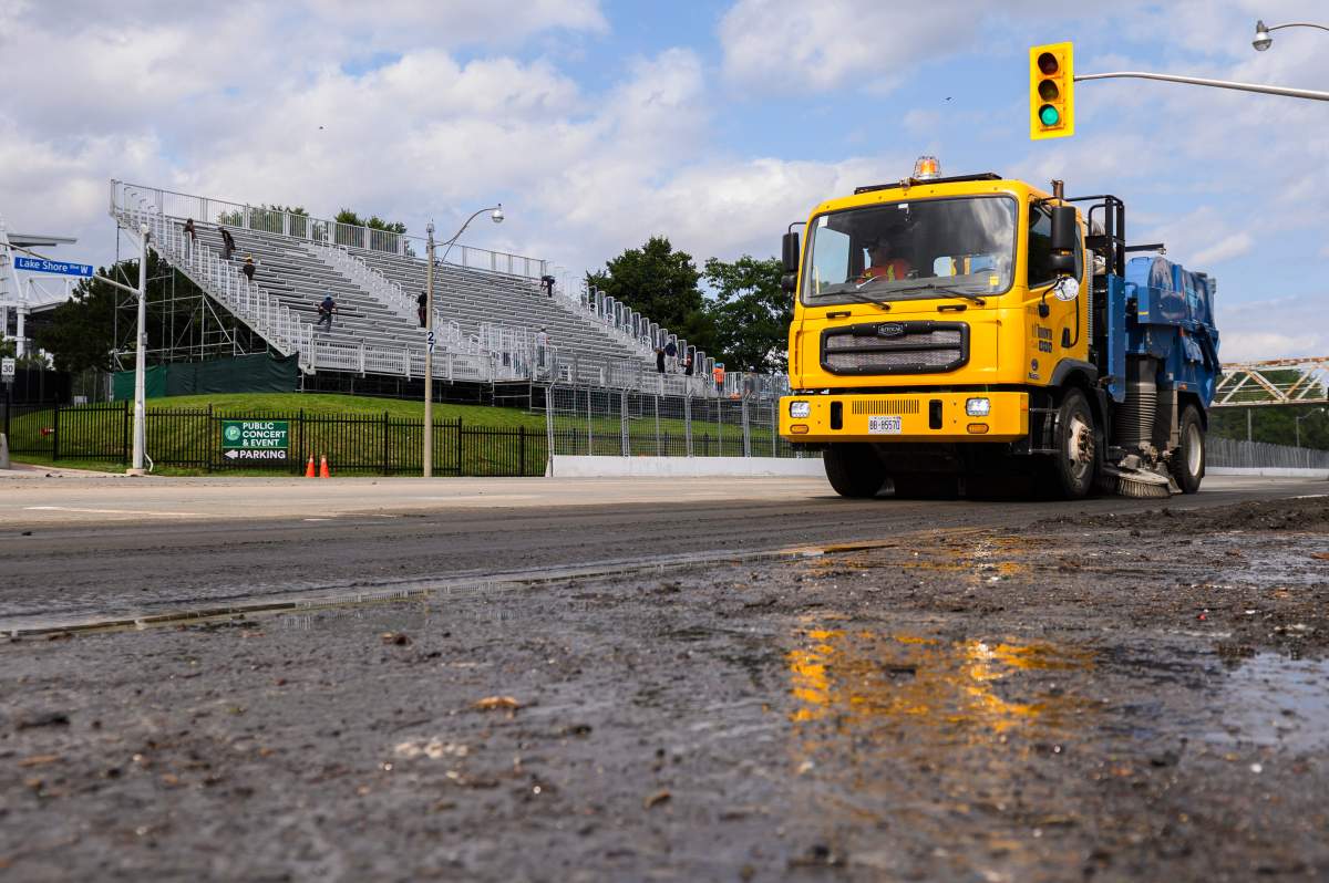 City crews clean up debris on Lake Shore Boulevard, after heavy rain caused flooding in Toronto on Tuesday, July 16, 2024.