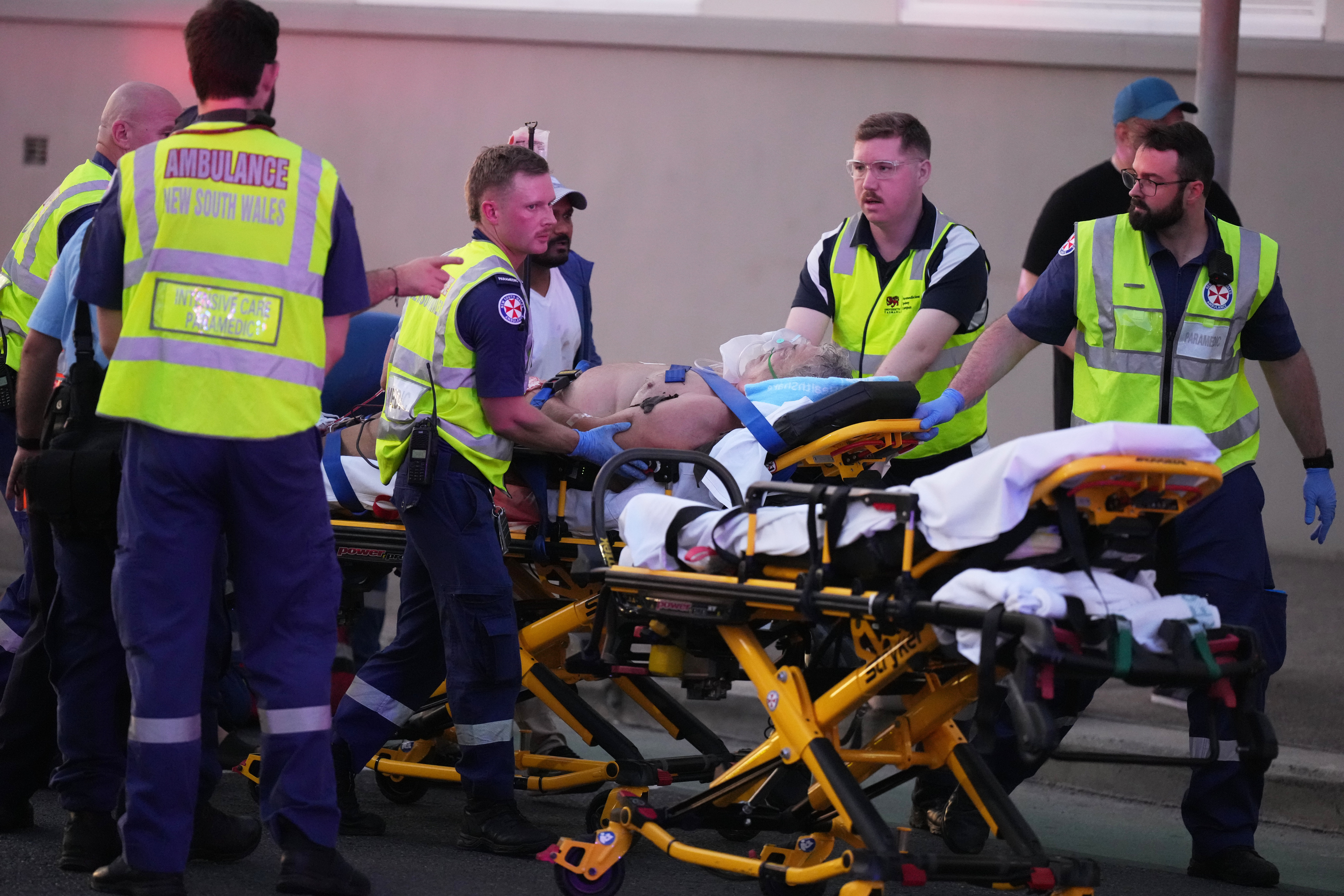 Emergency workers transport person on a stretcher after a shooting at Bondi Beach in Sydney, Dec. 14, 2025. (AP Photo/Mark Baker)