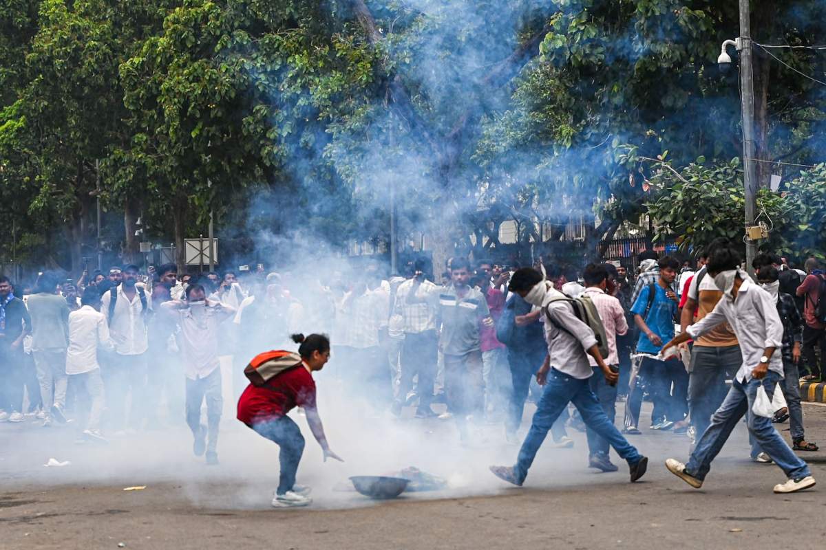 Supporters of the Cockroach Janta Party try to neutralize a tear gas shell fired by police as they attempt to march toward India’s Parliament, demanding the resignation of the education minister, in New Delhi, India, Monday, July 20, 2026. (AP Photo/Prakash Singh)