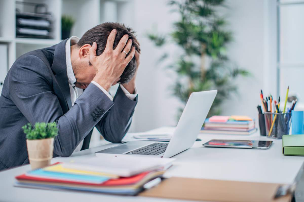 A businessman cries at his desk following his termination meeting.