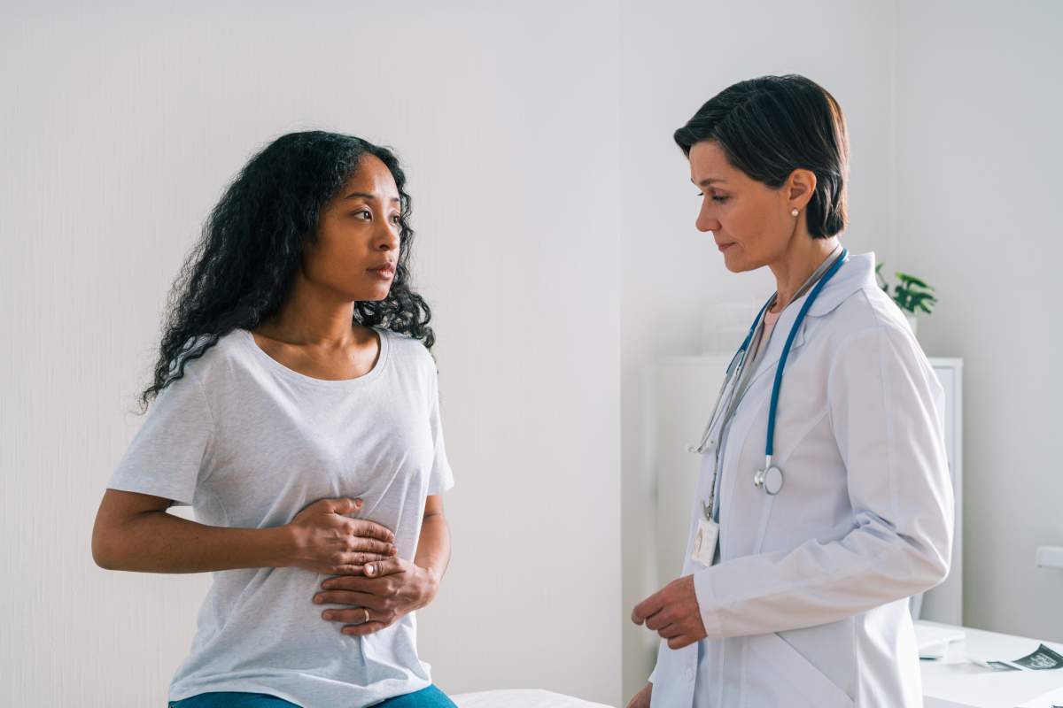 A woman tells her doctor about the abdominal pain she’s experiencing. 