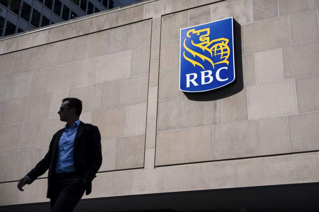 FILE - People walk past the Royal Bank Tower in Montreal on June 19, 2025. RBC has agreed to a proposed class-action settlement of $45 million related to trailing commissions.