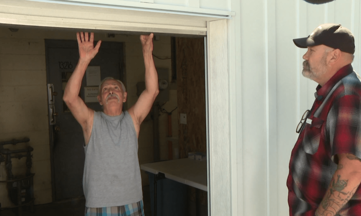 Frank Carriere opens the new gate that will help keep the volenteers safe