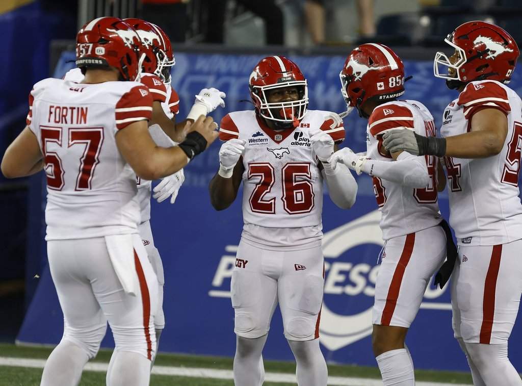 Calgary Stampeders' Dedrick Mills (26) celebrates his touchdown against the Winnipeg Blue Bombers during second half CFL football action in Winnipeg on Friday, July 24, 2026. THE CANADIAN PRESS/John Woods.