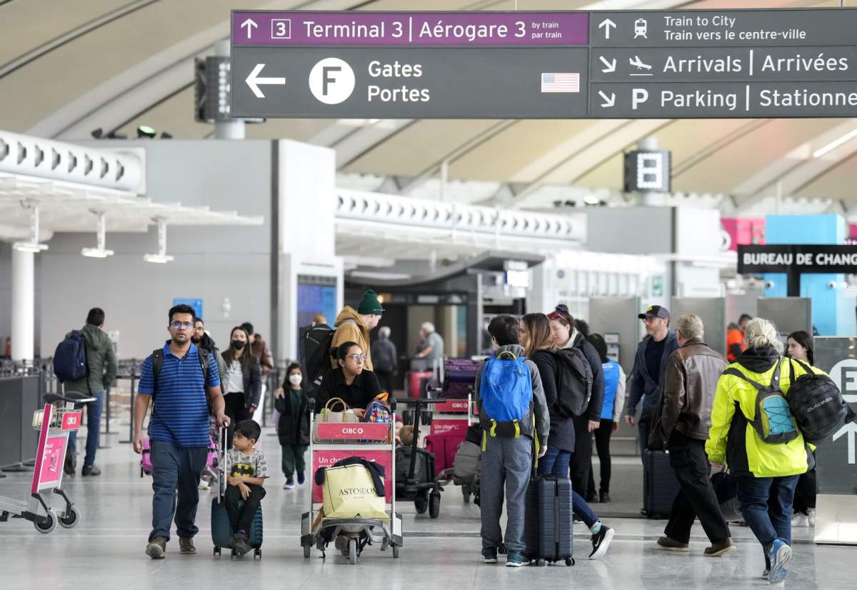 FILE: People walk through Toronto Pearson International Airport on March 10, 2023.