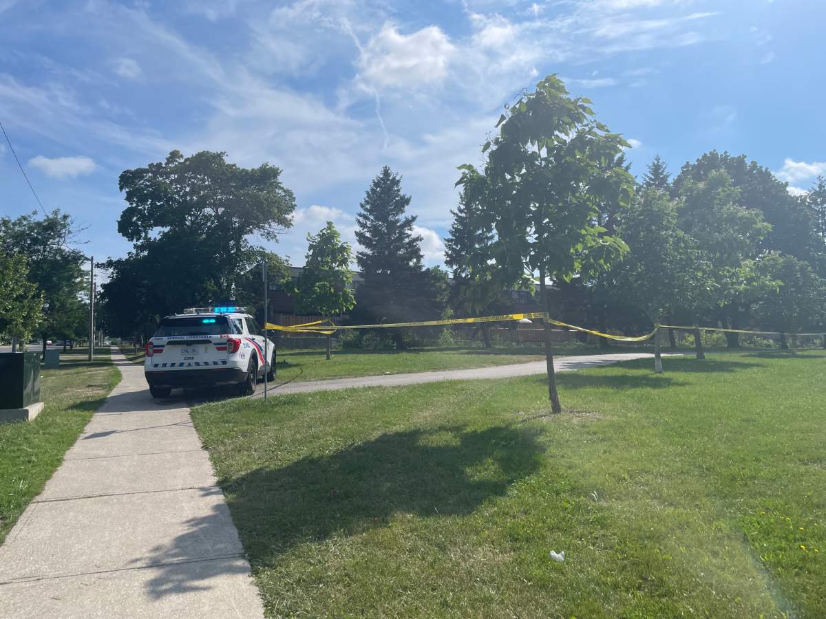 A police vehicle sits next to police tape as Toronto police investigate the shooting of two dogs on July 6, 2026.