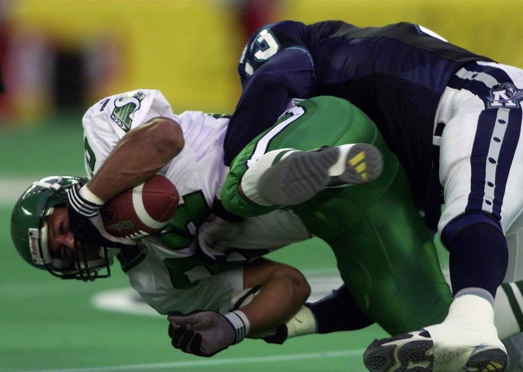 Saskatchewan Roughriders slotback Eric Guliford (84) is flipped up and hammered to the turf by Toronto Argonauts linebacker Calvin Tiggle during second-quarter CFL action in Toronto on Saturday, Aug. 25, 2001. (CP PHOTO/Frank Gunn).
