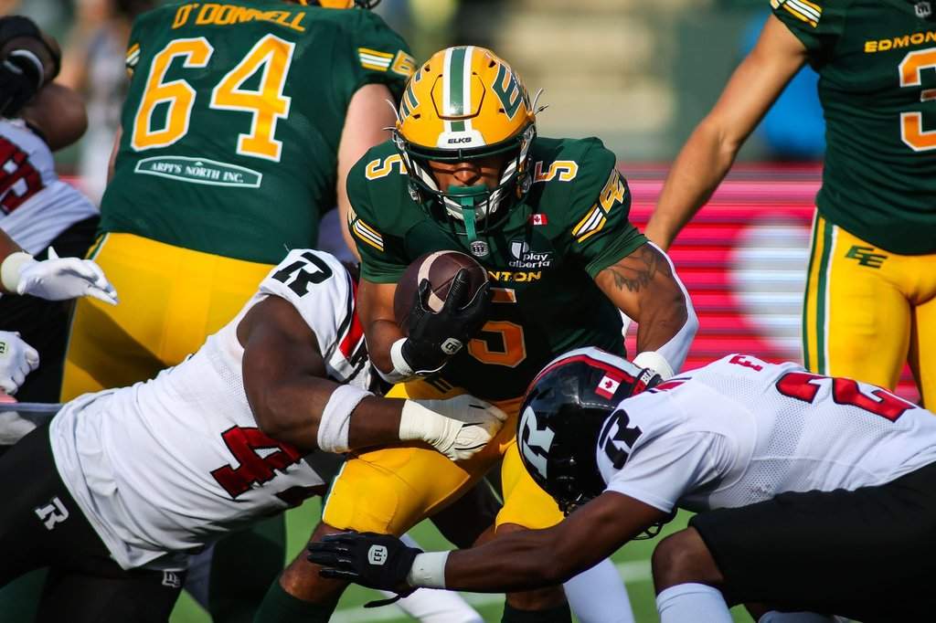 Edmonton Elks' Justin Rankin (5) is tackled by Ottawa Redblacks' Luiji Vilain (left) and Adrian Frye (22) during first half CFL football action in Edmonton on Thursday, July 9, 2026. THE CANADIAN PRESS/Codie McLachlan.