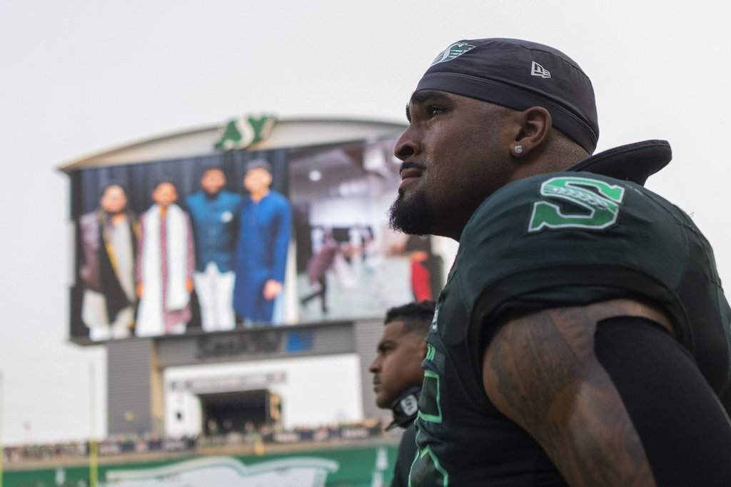 Saskatchewan Roughriders defensive lineman Devin Adams (95) reacts to a memorial video tribute to Roughrider linebacker Jayden Dalke, and Bhishma Rajyaguru, who were killed in a highway crash, prior to first half CFL football action against the Edmonton Elks in Regina on Thursday, July 23, 2026. THE CANADIAN PRESS/Kayle Neis.