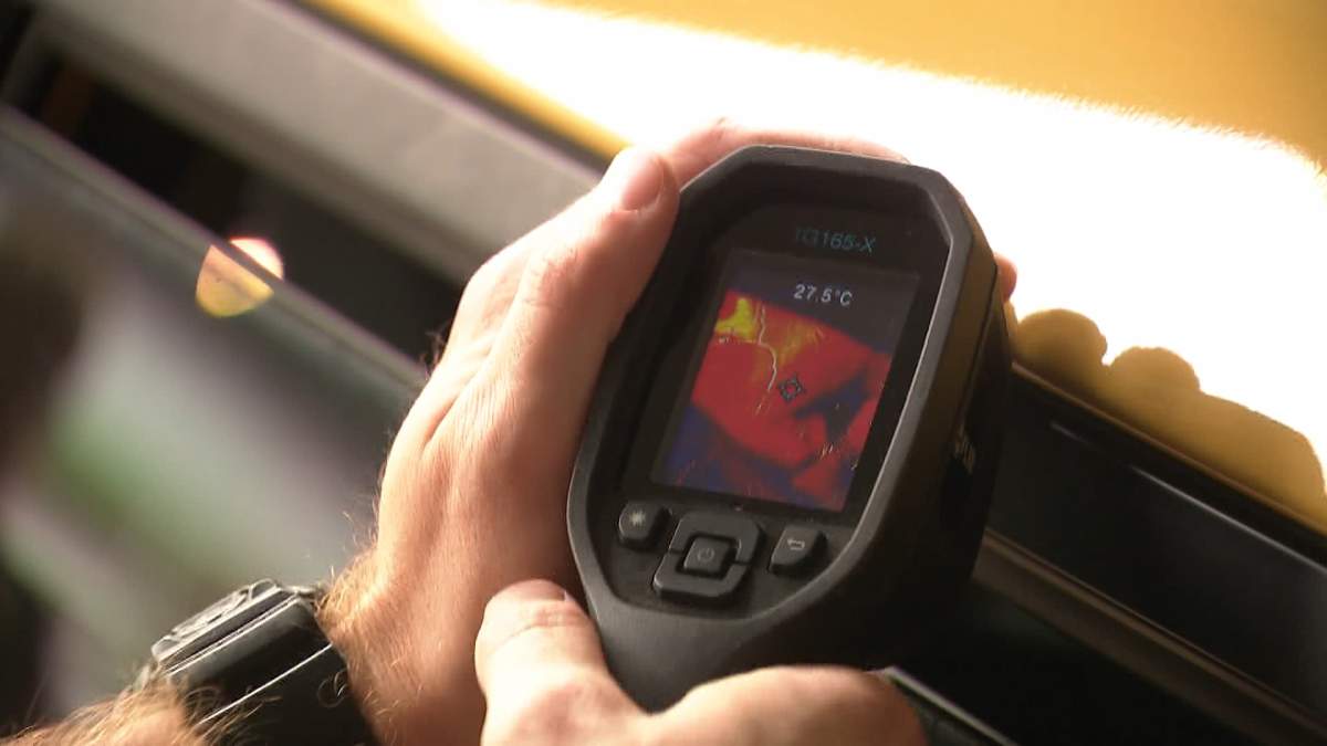 An officer with the City of Edmonton's Animal Protection Act Unit demonstrates how quickly temperatures inside a car, parked in the shade for just a few minutes, with the windows partway down, can increase to dangerous levels.
