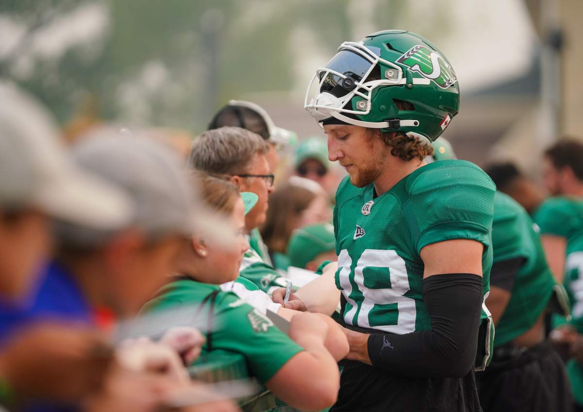 Saskatchewan Roughriders defensive back Jayden Dalke interacts with fan after a spring training scrimmage was cut short due to wildfire smoke in Saskatoon, Sask., on Saturday, May 20, 2023.