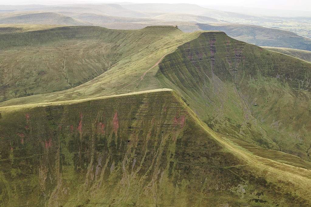 An aerial view of Pen y Fan highlights the intersecting ridgelines and elevated paths that connect the mountain's summit with nearby peaks including Corn Du and Cribyn, forming a distinctive upland landscape within the Brecon Beacons National Park.