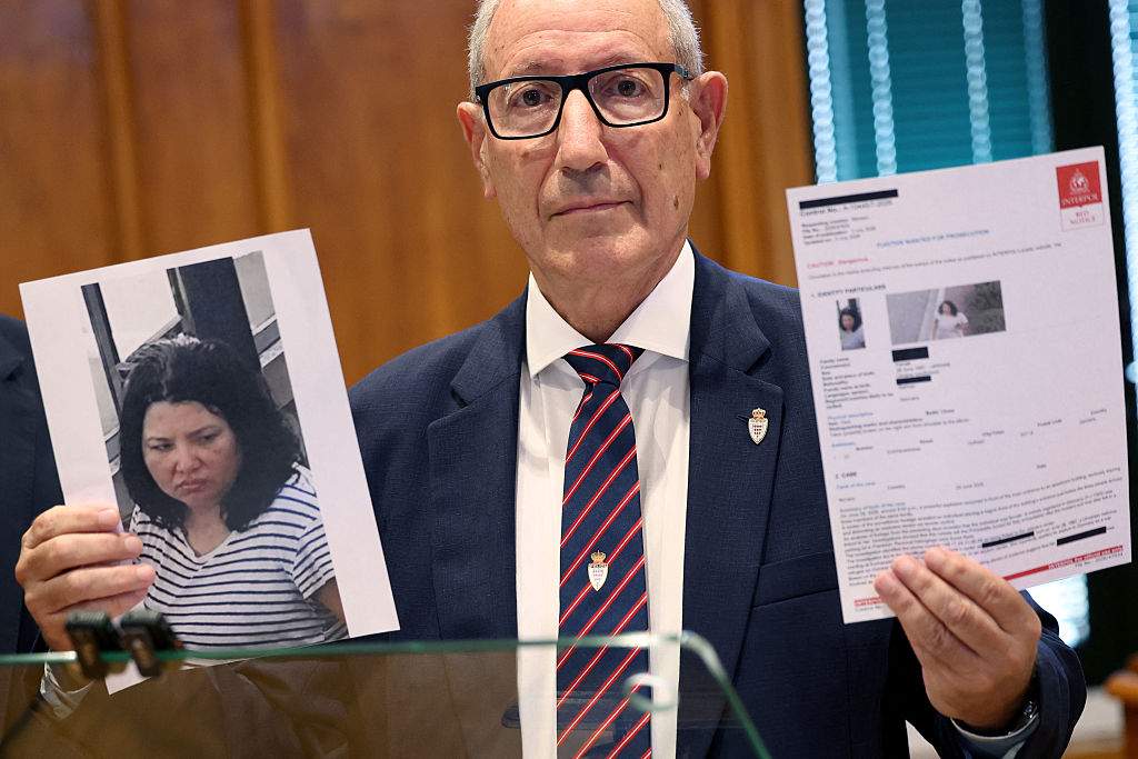 Monaco's public safety director, Eric Arella, holds up the red notice issued by Interpol against a Ukrainian woman suspected of planting a bomb in Monaco that injured three people, including a Ukrainian-born tycoon, during a press conference in Monaco on July 3, 2026.