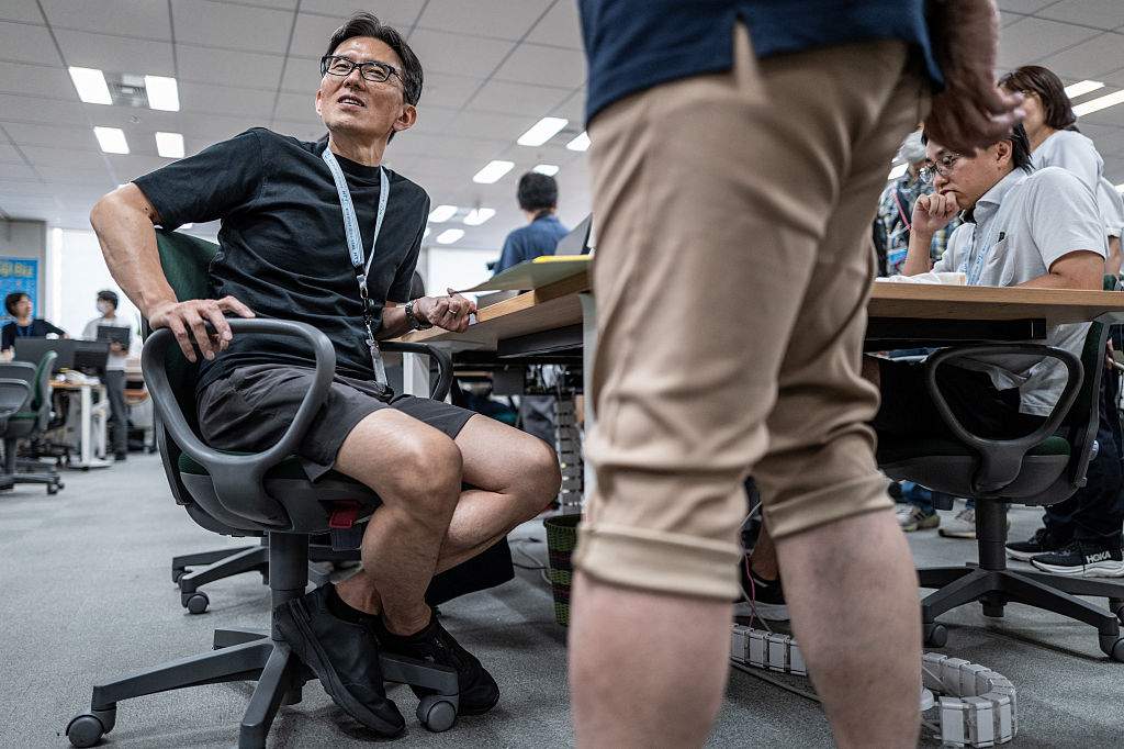 Government officials in casual dress code, including shorts, tee shirts and sneakers, work in the office of the Tokyo Metropolitan Government building, as part of the capital's "Cool Biz" initiative, in Tokyo on July 14, 2026.