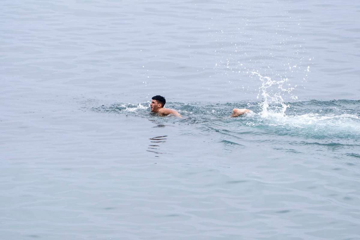 FILE- A boy swims as he attempts to cross from the Moroccan northern town of Fnideq to the Spanish enclave of Ceuta, Friday, July 31, 2026.