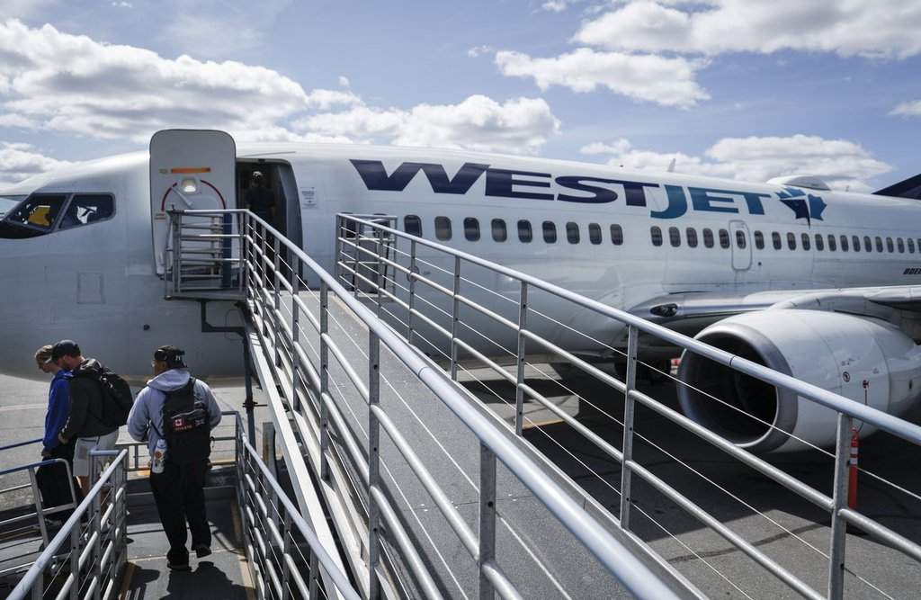 WestJet passengers deplane on the tarmac at Yellowknife Airport on Tuesday, July 22, 2025. THE CANADIAN PRESS/Jeff McIntosh.