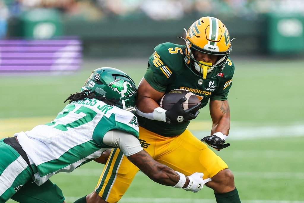 Edmonton Elks' Justin Rankin (5) is tackled by Saskatchewan Roughriders' James Burgess Jr. (27) during second half CFL football action in Edmonton on Saturday, August 1, 2026. THE CANADIAN PRESS/Codie McLachlan.