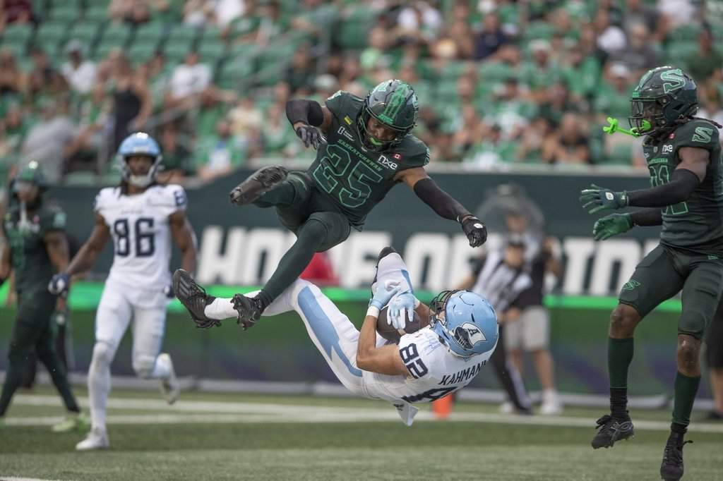 Toronto Argonauts' Tyler Kahmann (82) catches a touchdown pass as Saskatchewan Roughriders' Nelson Lokombo (25) defends during first half CFL action in Regina on Saturday, Aug. 29, 2026. THE CANADIAN PRESS/Kayle Neis.