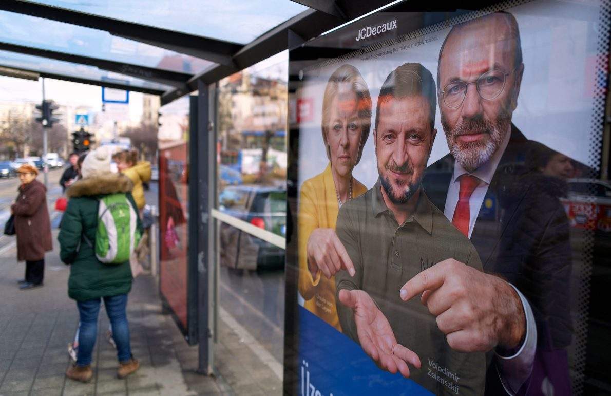 A billboard showing an AI-generated image of Ukrainian President Volodymyr Zelenskyy, centre, flanked by European officials is displayed at a bus stop in Budapest, Hungary, Monday, Feb. 23, 2026.