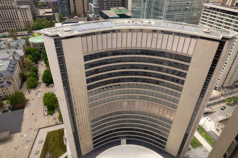 The curved west tower of Toronto City Hall is seen from atop the east tower on Saturday, May 24, 2025. The domed roof of council chambers is bottom centre. 
