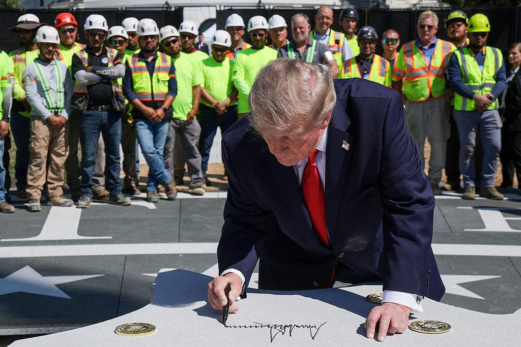 President Donald Trump signs a piece of granite that will be part of the new helipad on the South Lawn of the White House on August 19, 2026 in Washington, DC. Portions of the nearly completed helipad were removed recently due to modifications of the project.