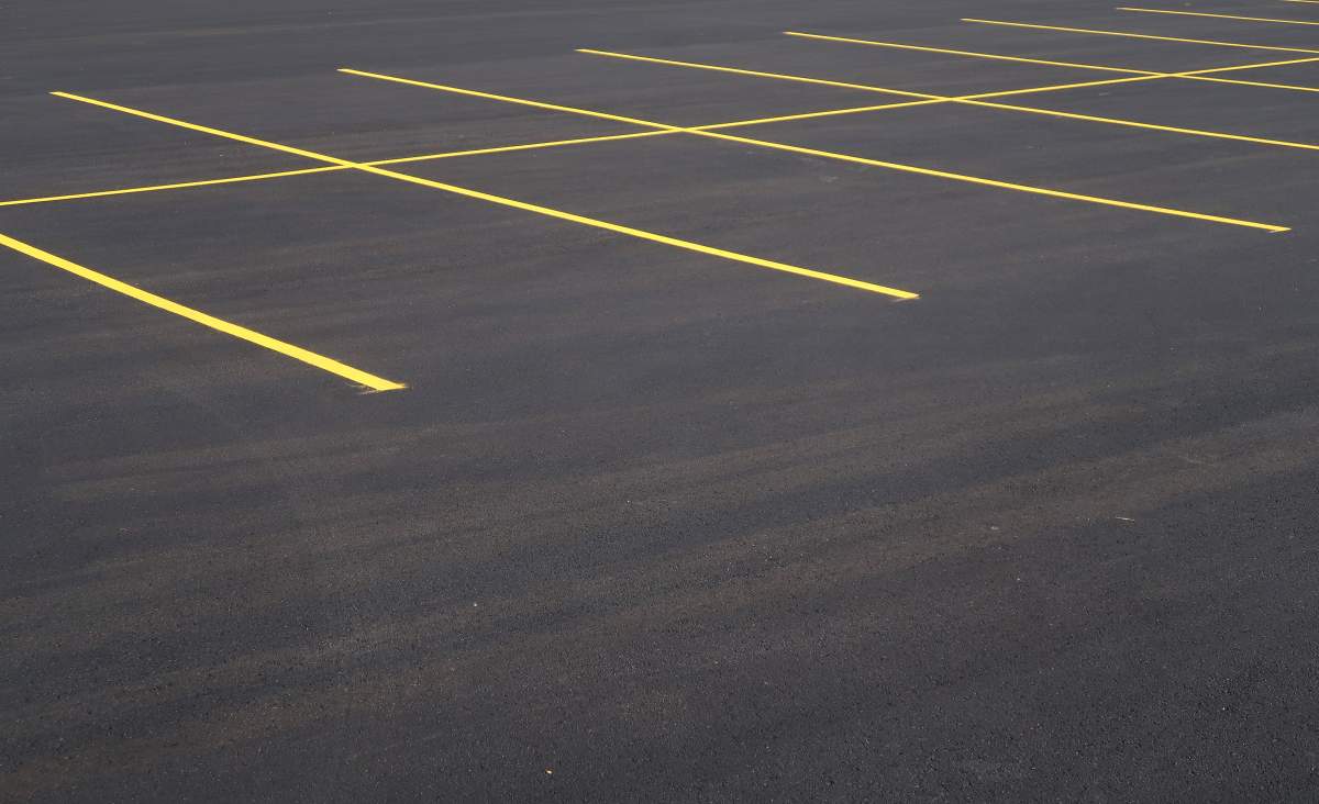 Yellow painted lines on parking spaces on fresh smooth asphalt.