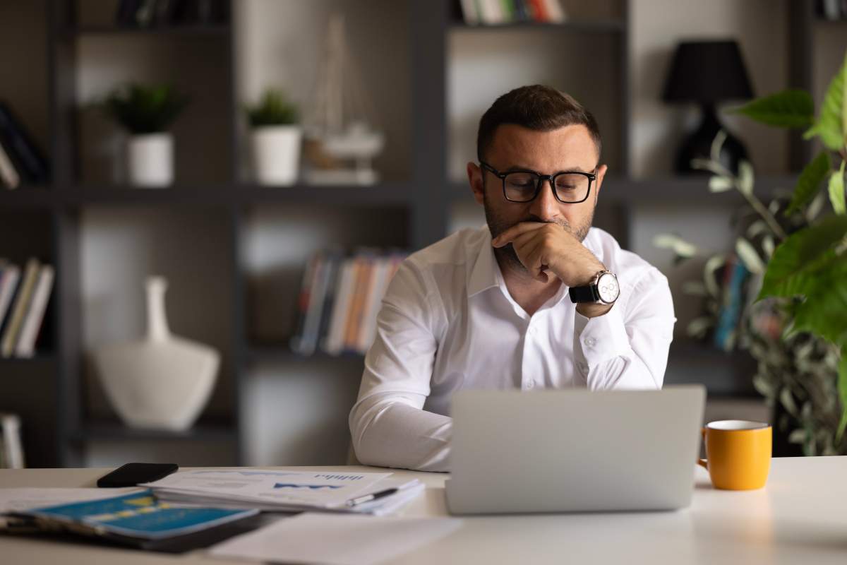Man looks at laptop screen feels confused experiencing problems.