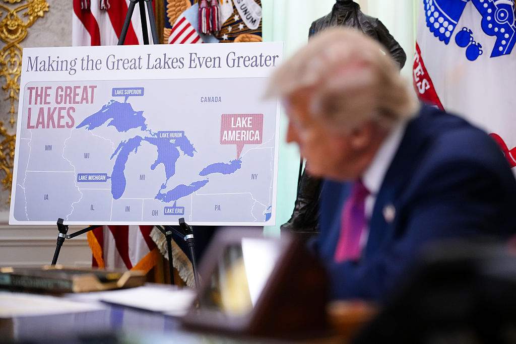 A map labeling Lake Ontario as “Lake America” is displayed as U.S. President Donald Trump signs an executive order during an event in the Oval Office of the White House on August 27, 2026 in Washington, DC.