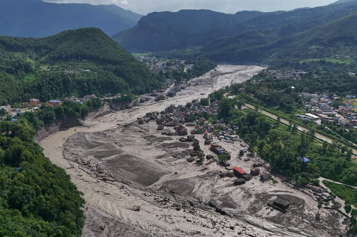 Damaged houses stand precariously near the swollen, debris-choked banks of the Trishuli River after flash floods in Nepal’s Nuwakot district on Wednesday, Aug. 26, 2026. (AP Photo/Niranjan Shrestha)