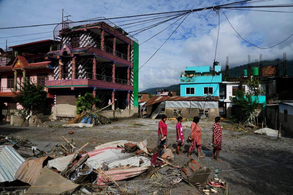 People walk past damage in the aftermath of flash floods in Devighat in the Nuwakot district in Nepal, Thursday, Aug 27, 2026.