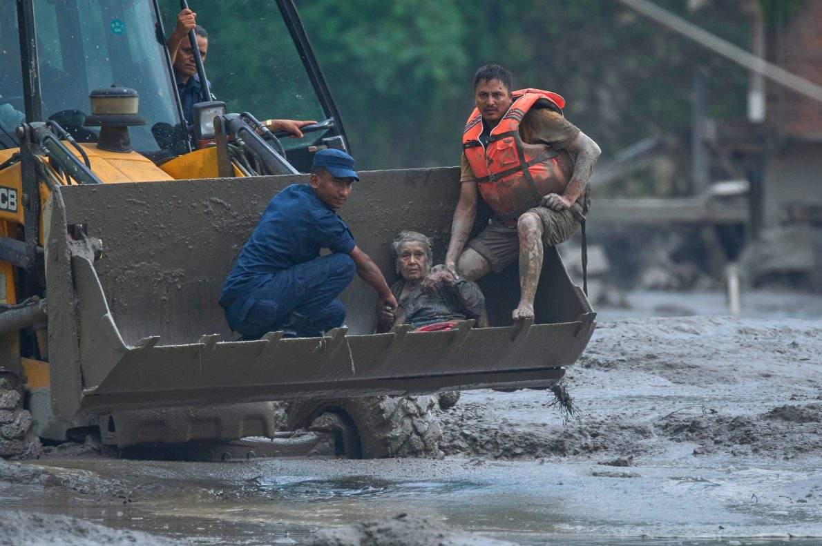 Rescuers use an earthmover to carry a victim of flash flooding to safety along the Trishuli River in Nepal’s Nuwakot district, Wednesday, Aug. 26, 2026.
