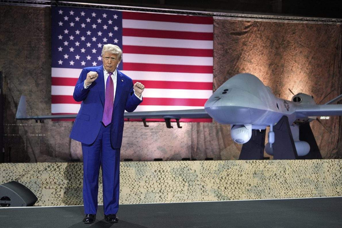FILE - U.S. President Donald Trump gestures backdropped by an MQ-9 Reaper drone at the Al Udeid Air Base, Thursday, May 15, 2025, in Doha, Qatar. 